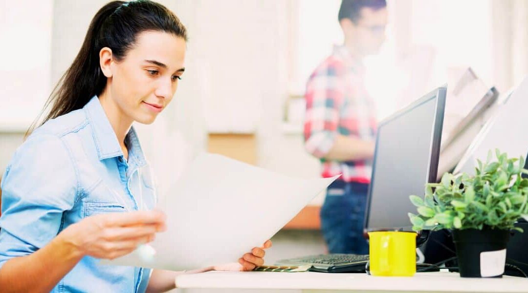 woman looking at documents at her desk