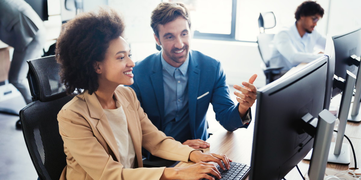 two business professionals looking at monitor